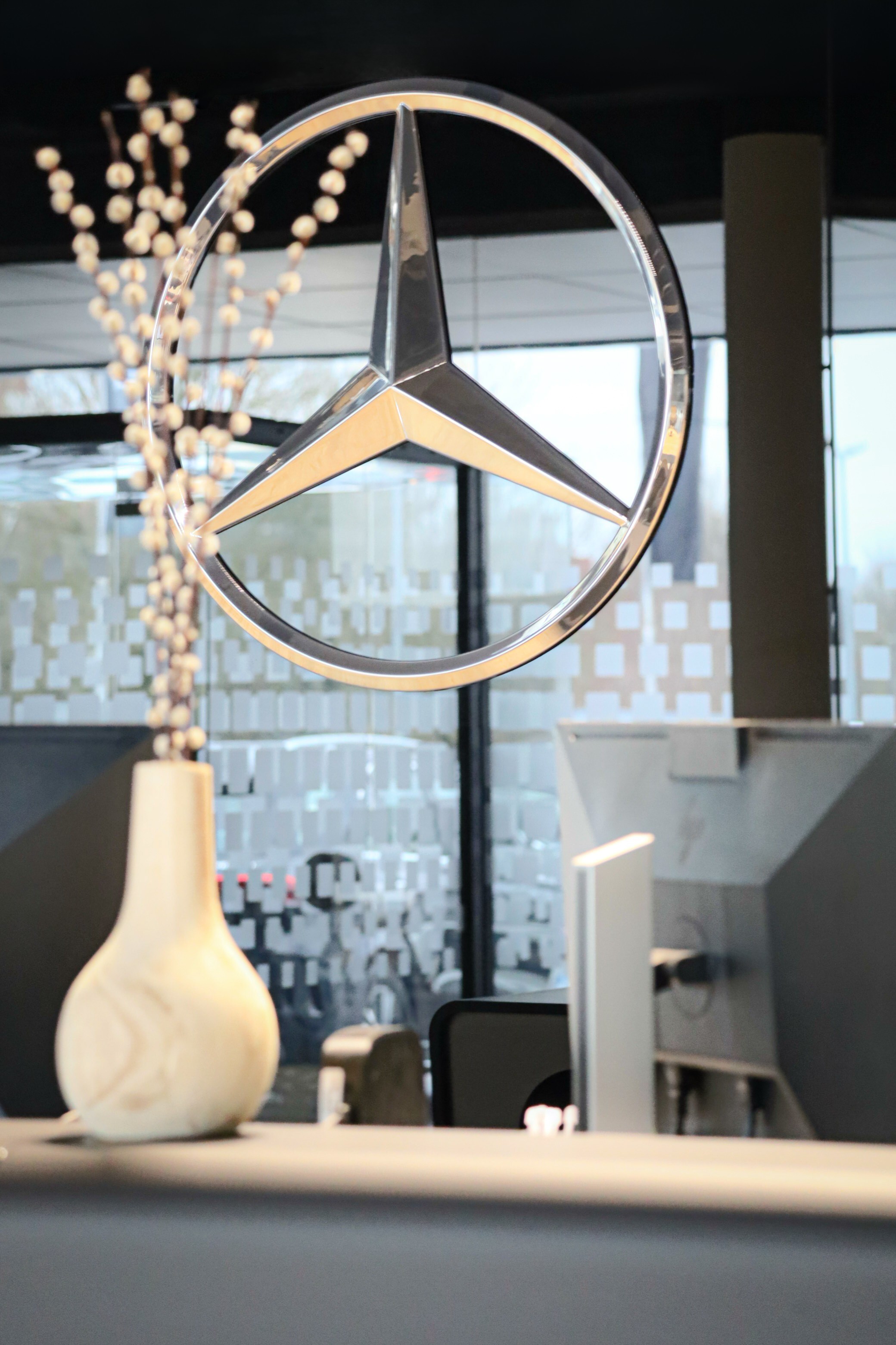 Kundenempfang bei Merbag. Mercedes-Stern auf schwarzer Wand.